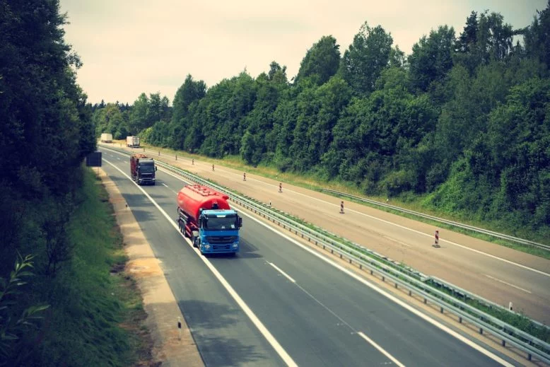 Carretera rodeada de árboles, alto tránsito de camiones que es infravalorado