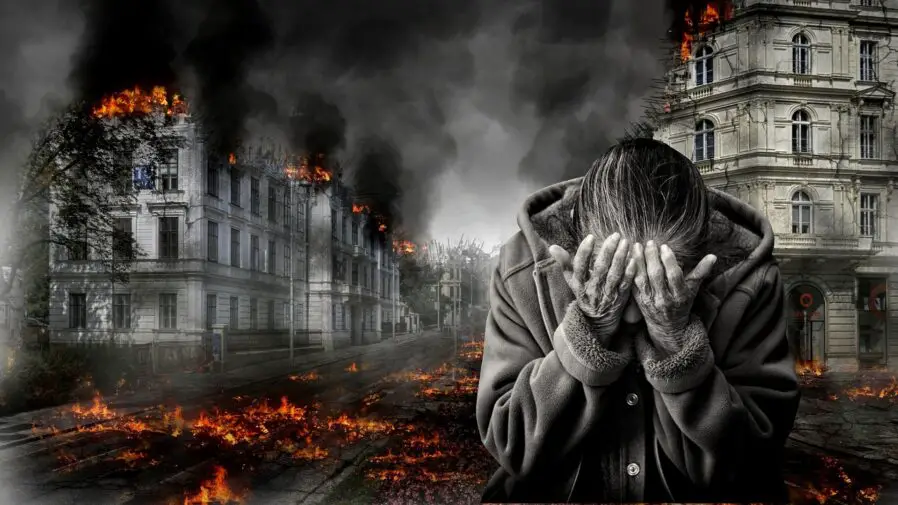 Persona tapando el rostro con las manos por el dolor ante el incendio.