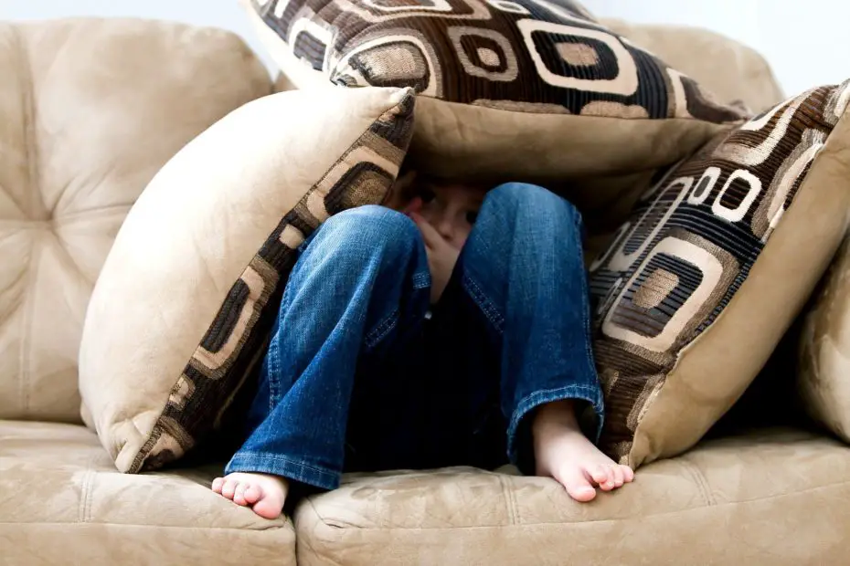 Un niño semisentado y tapado con almohadones en un sillón, donde apenas pueden verse sus ojos por el pánico.