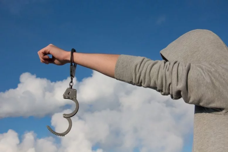 Persona extendiendo un brazo con grillete abierto, en señal de independencia y libertad