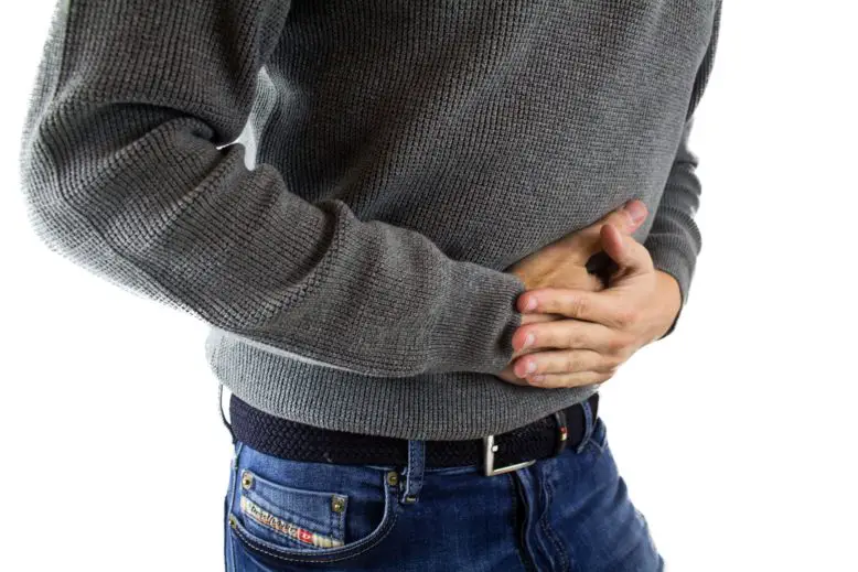 Hombre tomando su abdomen por dolor de cancer gastrico