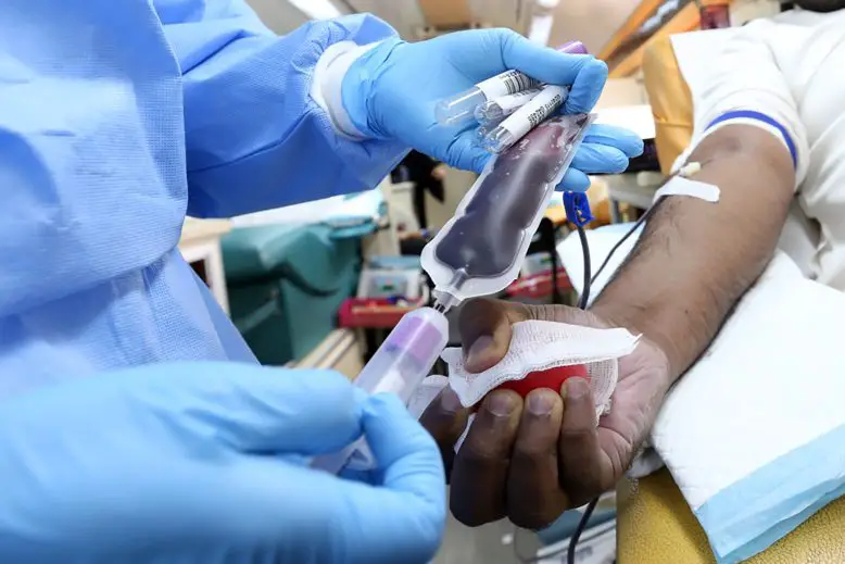 médico con jeringa administrando a paciente donación de plasma