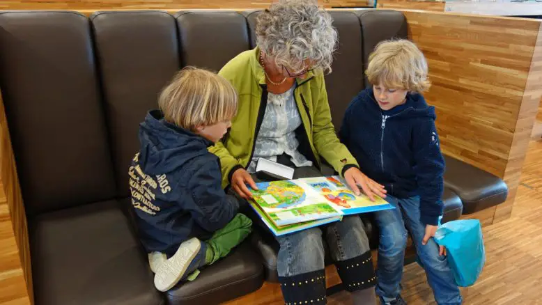abuela enseñando a leer a dos niños pronuncia sílaba tónica
